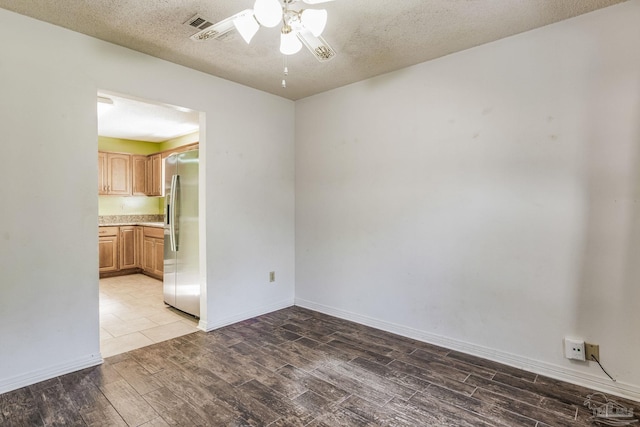 spare room featuring ceiling fan, wood-type flooring, and a textured ceiling