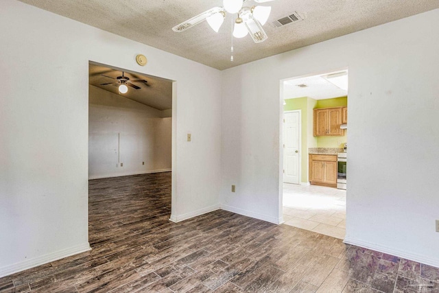 empty room with dark hardwood / wood-style floors and a textured ceiling