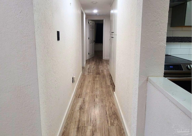 corridor with light hardwood / wood-style flooring