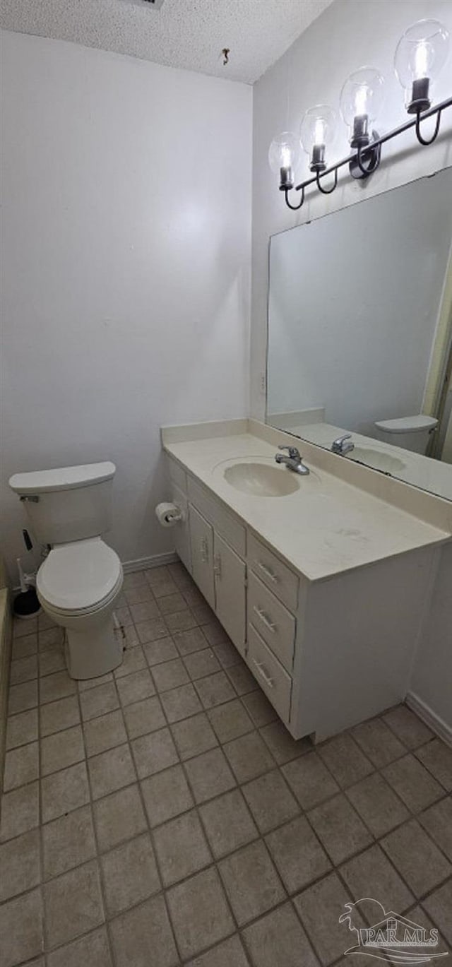 bathroom with vanity, a textured ceiling, and toilet