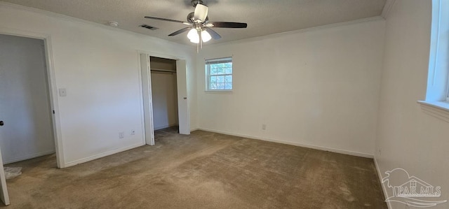 unfurnished bedroom featuring ceiling fan, crown molding, carpet, and a textured ceiling