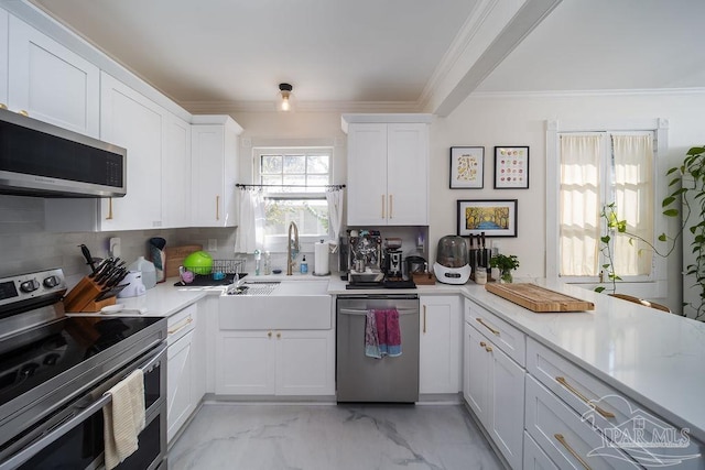 kitchen featuring sink, backsplash, appliances with stainless steel finishes, ornamental molding, and white cabinetry