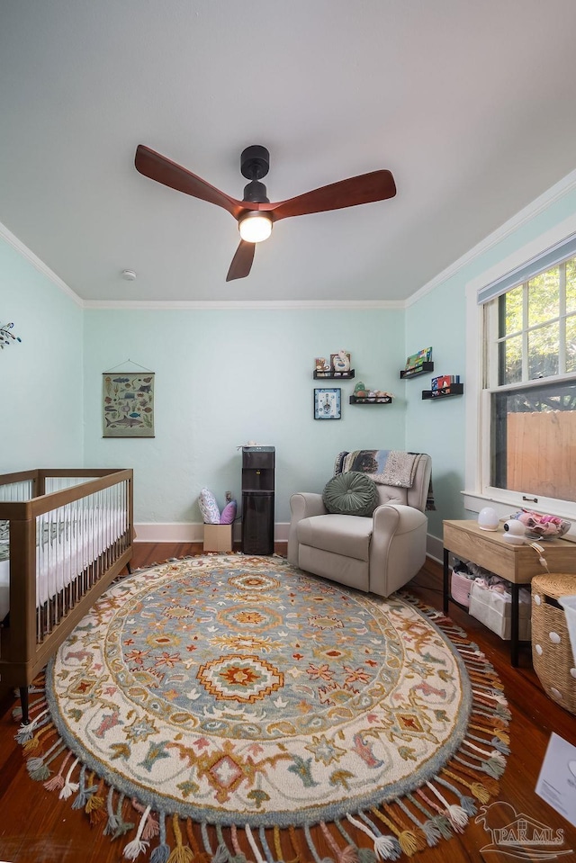 living room with wood-type flooring, ornamental molding, and ceiling fan