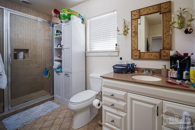 bathroom featuring toilet, tile patterned flooring, vanity, and a shower with shower door