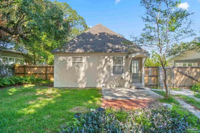 rear view of property with a lawn and a patio