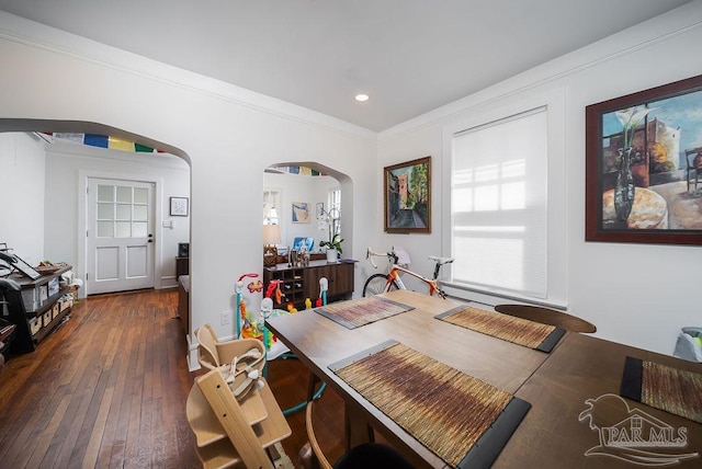 dining area with ornamental molding and dark hardwood / wood-style flooring