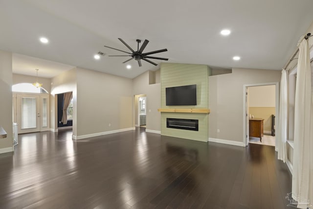 unfurnished living room with lofted ceiling, a large fireplace, dark hardwood / wood-style floors, a wealth of natural light, and ceiling fan