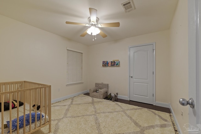 bedroom featuring a crib and ceiling fan