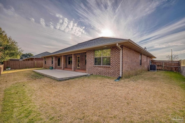 back of property with a lawn, cooling unit, and a patio area