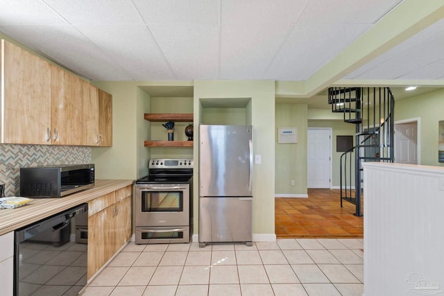 kitchen with tasteful backsplash, appliances with stainless steel finishes, and light tile patterned floors