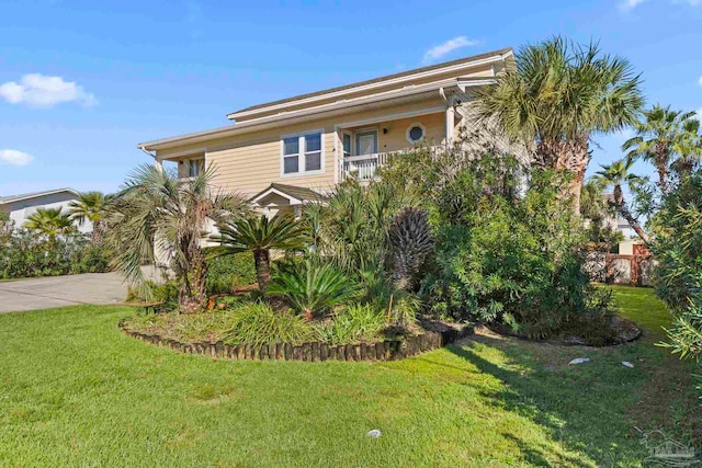 view of front of house featuring a front lawn and a balcony