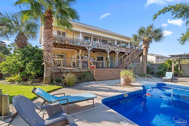 view of swimming pool featuring a patio area and a wooden deck