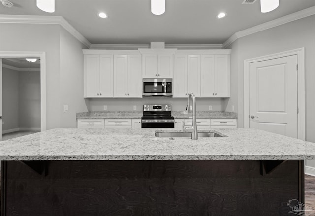 6621 Rocky Shores Rd, Milton, FL 32583 - kitchen featuring stainless steel appliances, a sink, baseboards, a center island with sink, and white cabinets