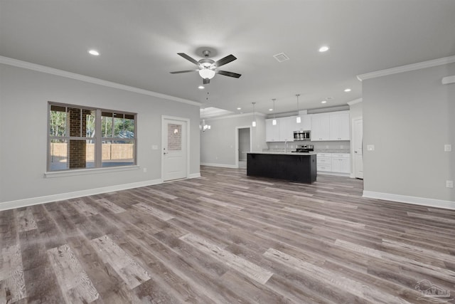 6621 Rocky Shores Rd, Milton, FL 32583 - unfurnished living room featuring ceiling fan, crown molding, recessed lighting, baseboards, and wood finished floors