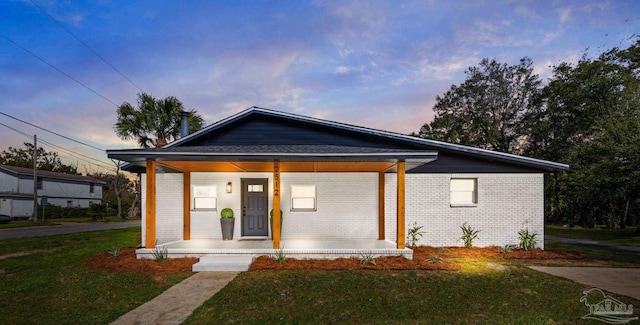 2512 N 8th Ave, Pensacola, FL 32503 - view of front of home with a porch, brick siding, and a lawn