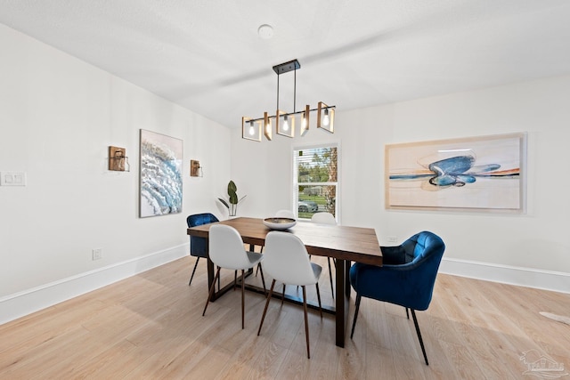 dining room featuring an inviting chandelier, baseboards, and wood finished floors