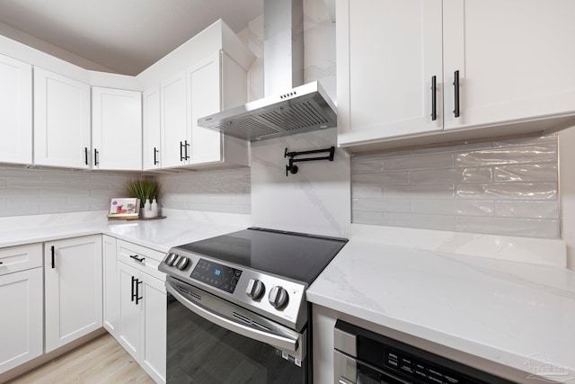 2512 N 8th Ave, Pensacola, FL 32503 - kitchen with wall chimney range hood, electric stove, white cabinets, tasteful backsplash, and light stone countertops