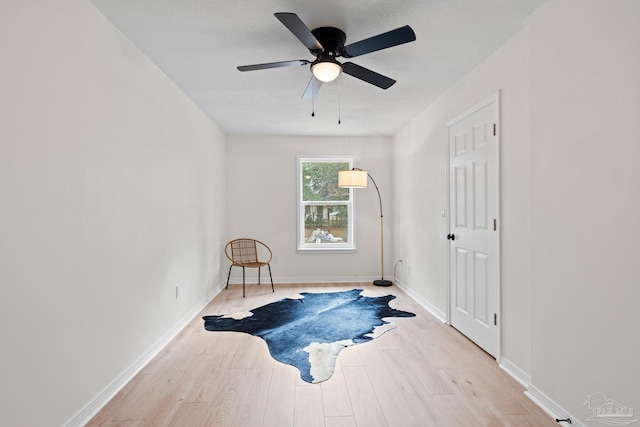 sitting room featuring a ceiling fan, baseboards, and wood finished floors