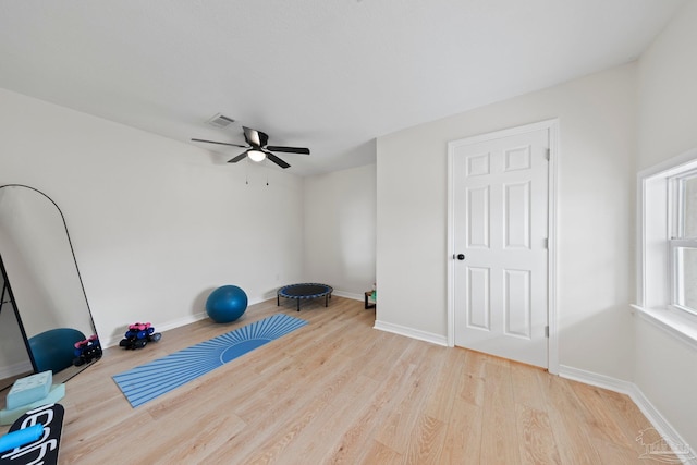 workout room featuring visible vents, baseboards, and wood finished floors