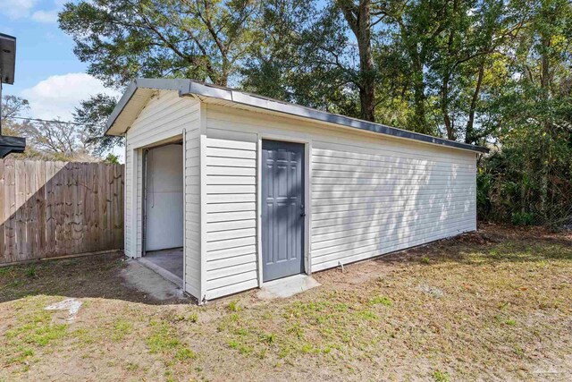 view of outdoor structure featuring fence and an outdoor structure