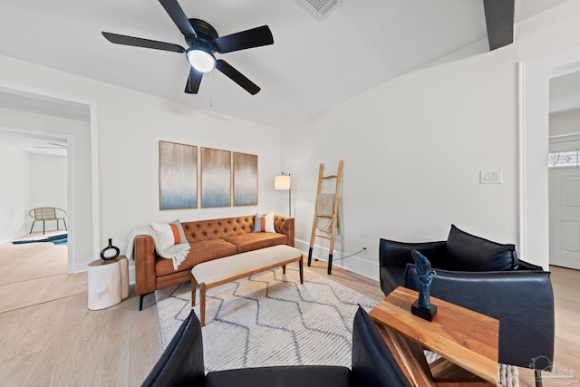 living room with ceiling fan, visible vents, light wood-style flooring, and baseboards