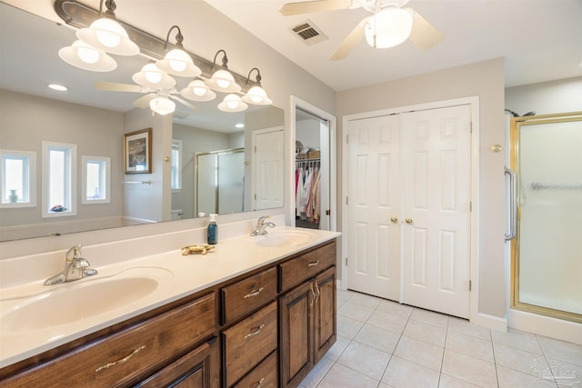 9638 Wills Ln, Lillian, AL 36549 - bathroom featuring a ceiling fan, a stall shower, tile patterned flooring, double vanity, and a walk in closet