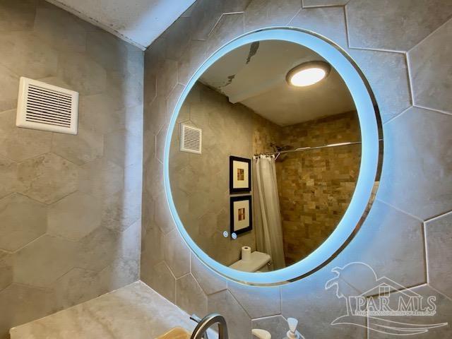 interior space with tiled shower and visible vents