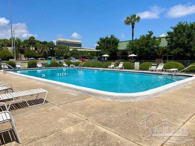 community pool featuring a patio and fence