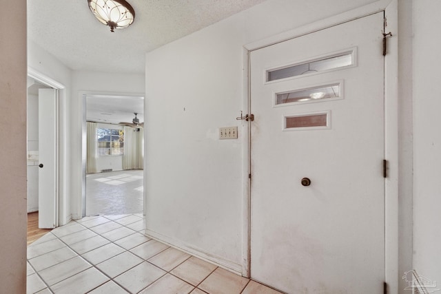 hallway featuring light tile patterned floors and a textured ceiling