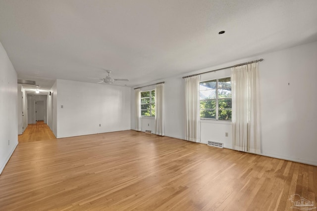 unfurnished room with ceiling fan and light wood-type flooring