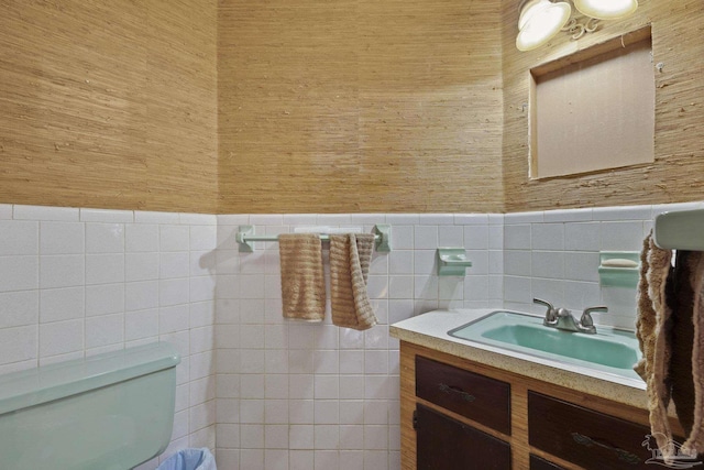 bathroom with vanity, toilet, and tile walls