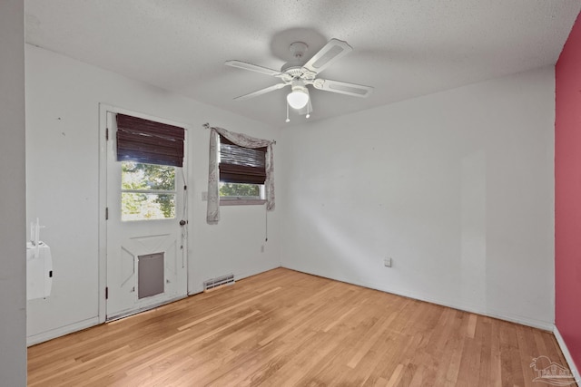 unfurnished room featuring ceiling fan, light hardwood / wood-style flooring, and a textured ceiling