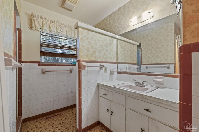 bathroom with vanity and tile walls