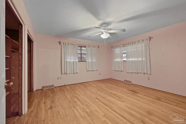 unfurnished bedroom with ceiling fan, light hardwood / wood-style floors, and a textured ceiling