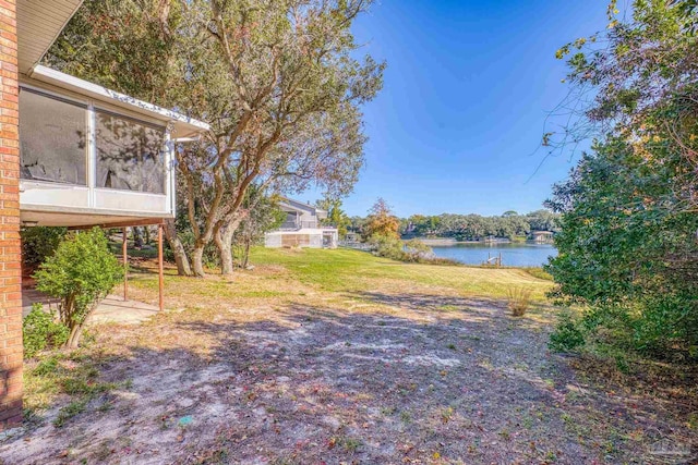 view of yard featuring a water view and a sunroom