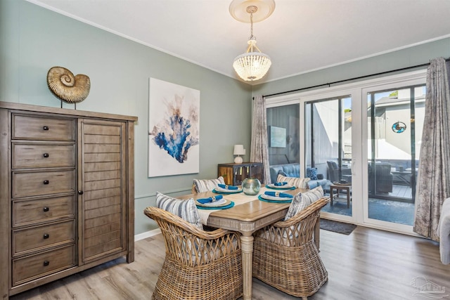 dining space with light wood-type flooring and ornamental molding