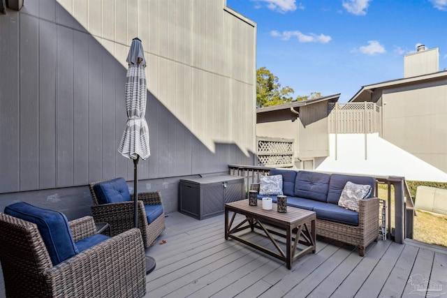 wooden terrace with an outdoor living space