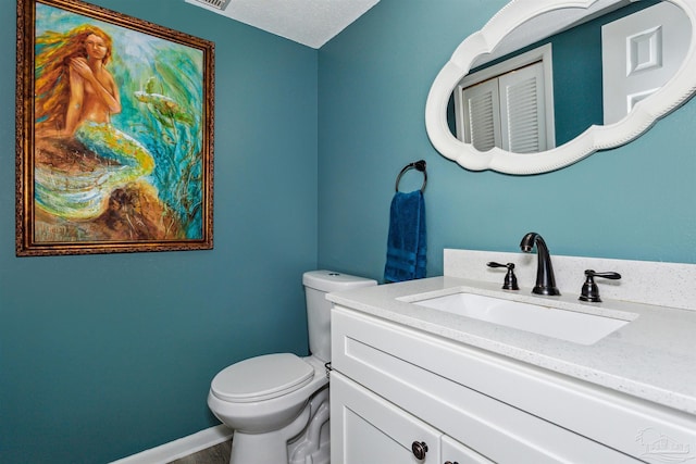 bathroom with vanity, a textured ceiling, and toilet