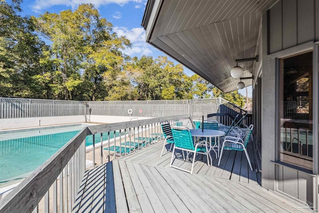 wooden deck with a fenced in pool