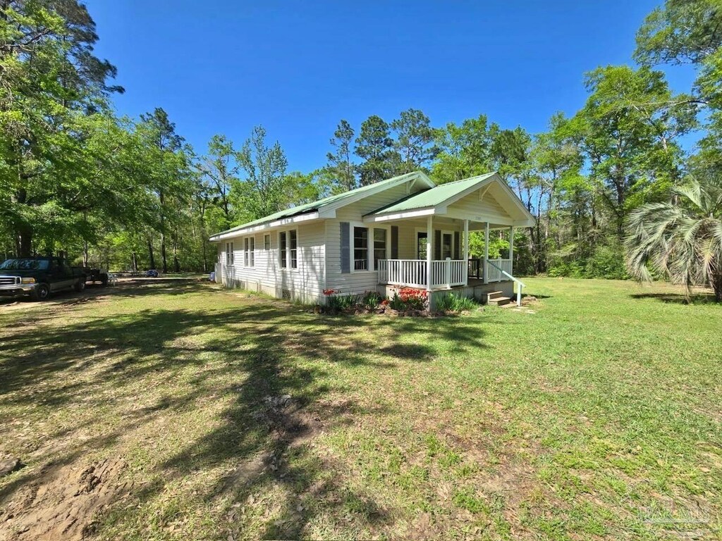 exterior space featuring covered porch and a lawn