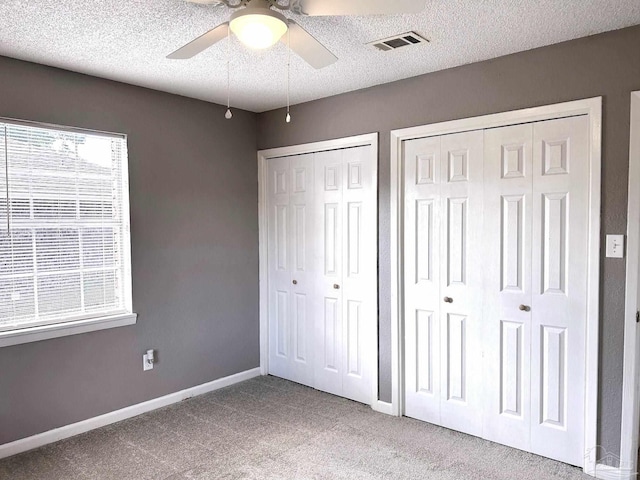 2500 Inda Ave, Pensacola, FL 32526 - unfurnished bedroom with baseboards, visible vents, carpet, a textured ceiling, and two closets