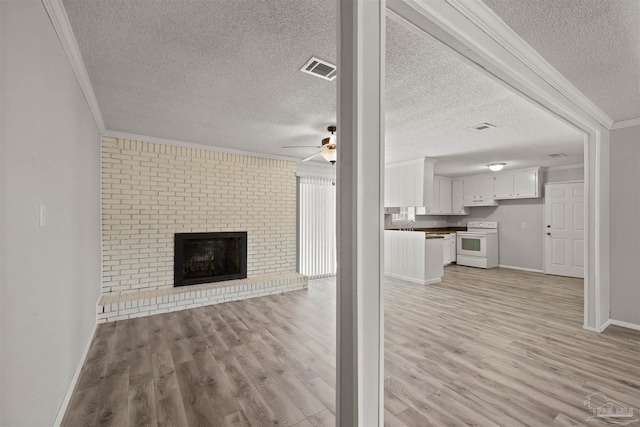2500 Inda Ave, Pensacola, FL 32526 - unfurnished living room featuring light wood finished floors, baseboards, ceiling fan, ornamental molding, and a brick fireplace