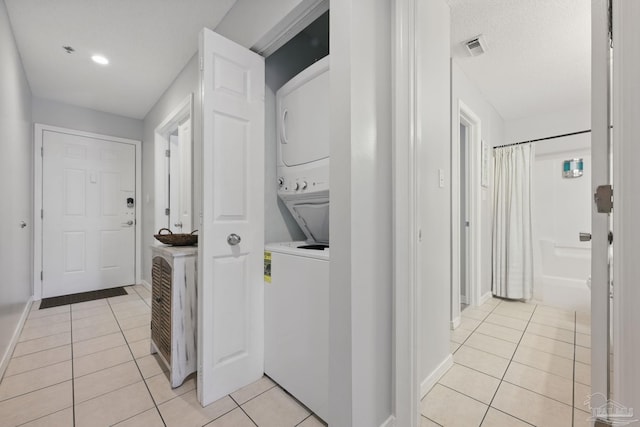 3191 Scenic Highway 98 Unit 212, Destin, FL 32541 - laundry area featuring stacked washing machine and dryer, light tile patterned floors, and recessed lighting