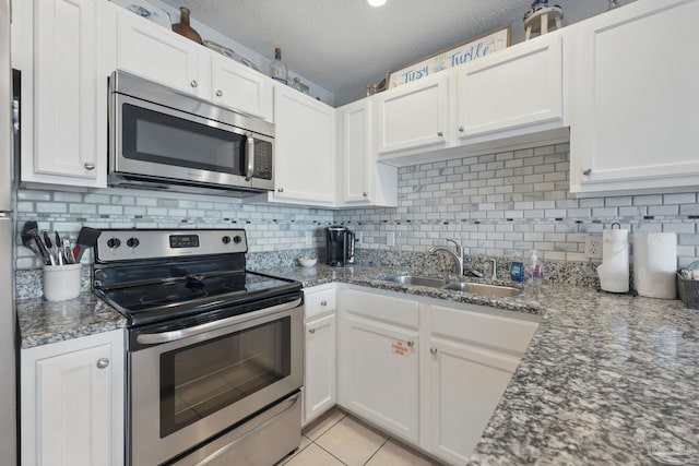 3191 Scenic Highway 98 Unit 212, Destin, FL 32541 - kitchen with stainless steel appliances, white cabinetry, backsplash, dark stone countertops, and a textured ceiling