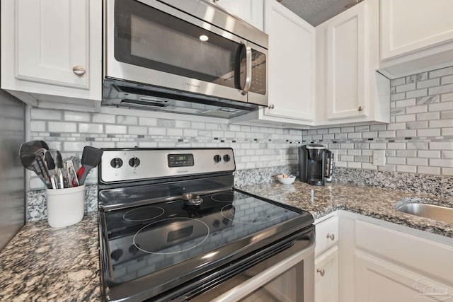 3191 Scenic Highway 98 Unit 212, Destin, FL 32541 - kitchen with stainless steel appliances, white cabinetry, tasteful backsplash, and dark stone countertops