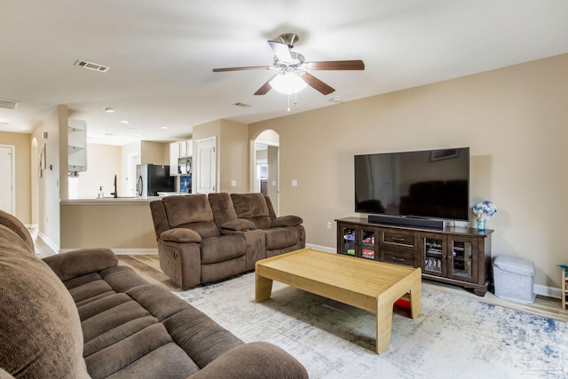 living room featuring sink, light hardwood / wood-style flooring, and ceiling fan