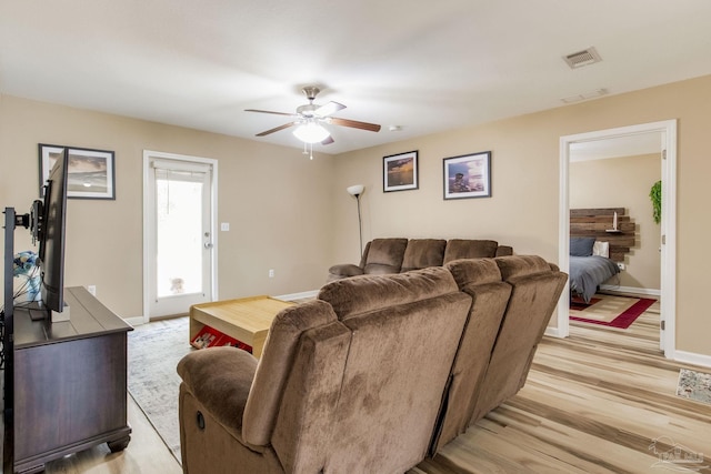 living room with light hardwood / wood-style floors and ceiling fan