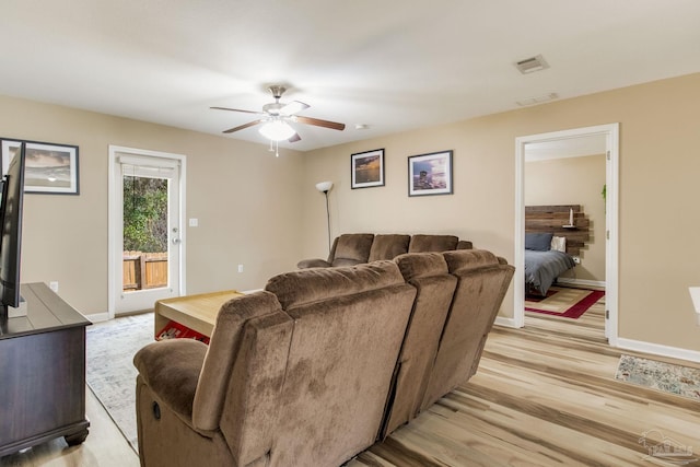 living room with light hardwood / wood-style flooring and ceiling fan