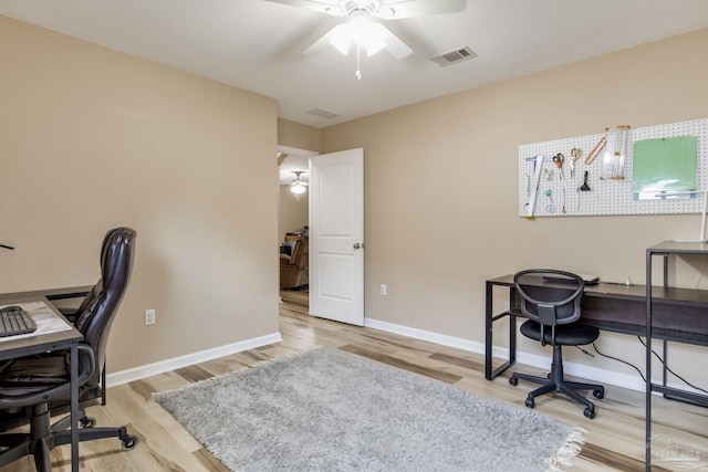 home office with light hardwood / wood-style flooring and ceiling fan