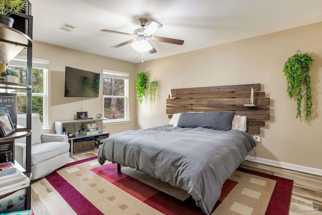 bedroom with light hardwood / wood-style floors and ceiling fan